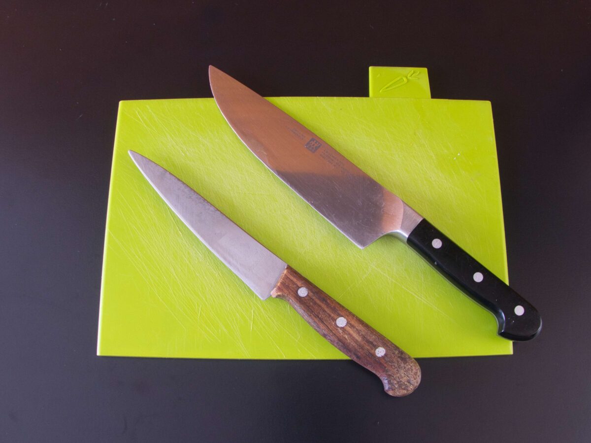 A sharp knife and chopping board, essential for preparing fresh ingredients for Thai green curry paste