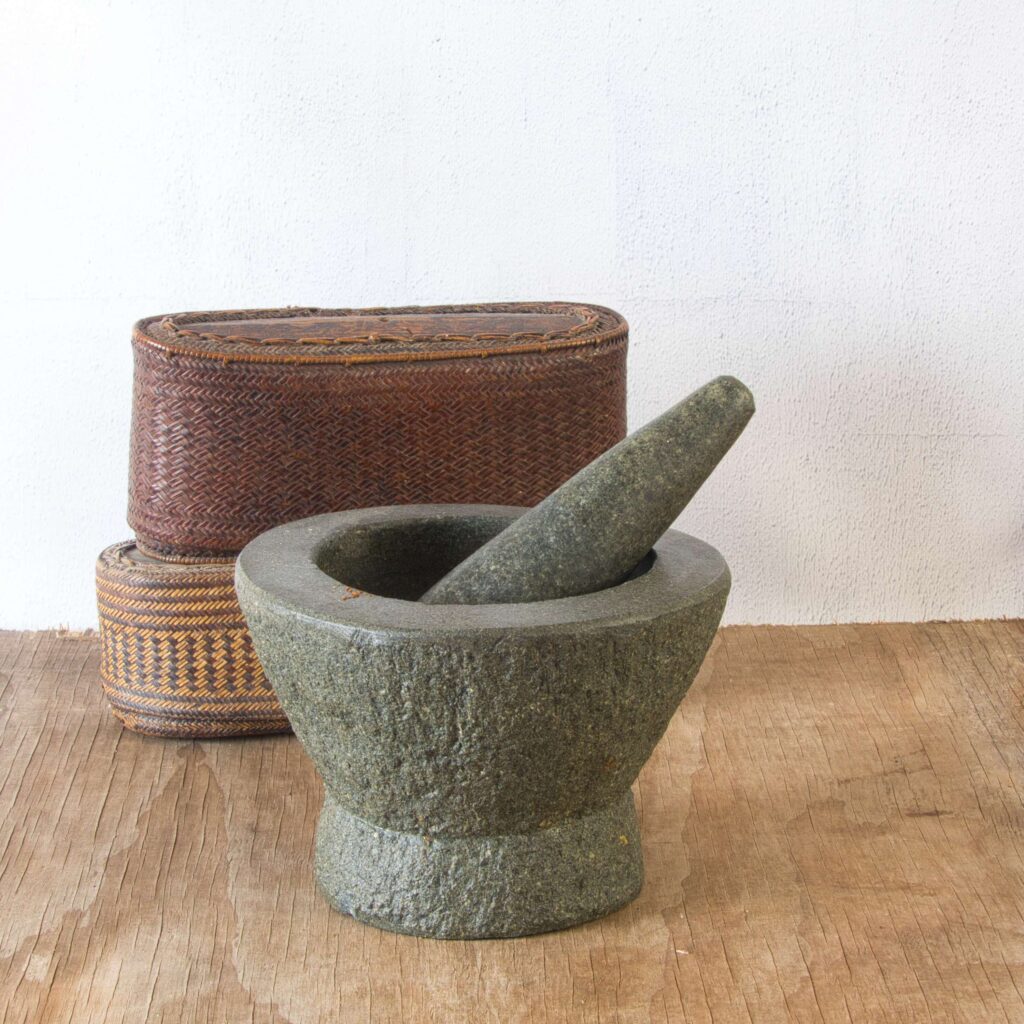 “Granite mortar and pestle used in Thai cooking to grind spices and make curry pastes”