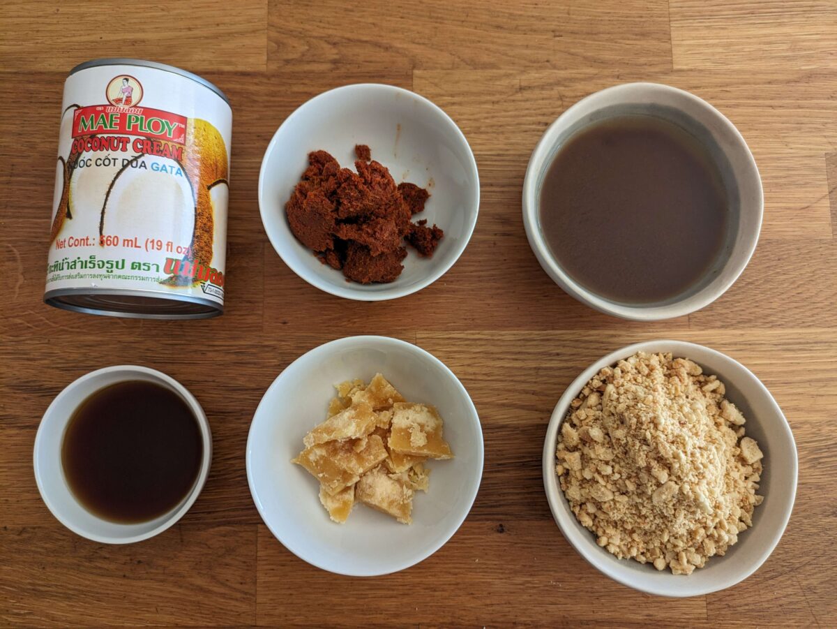 "Ingredients for Thai peanut sauce with peanuts, coconut cream, red curry paste, palm sugar and fish sauce"