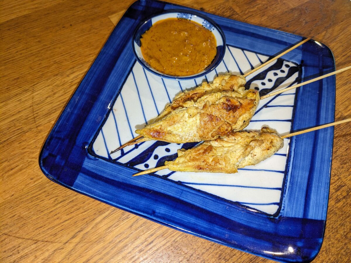 "Grilled chicken satay skewers served with creamy Thai peanut sauce"
