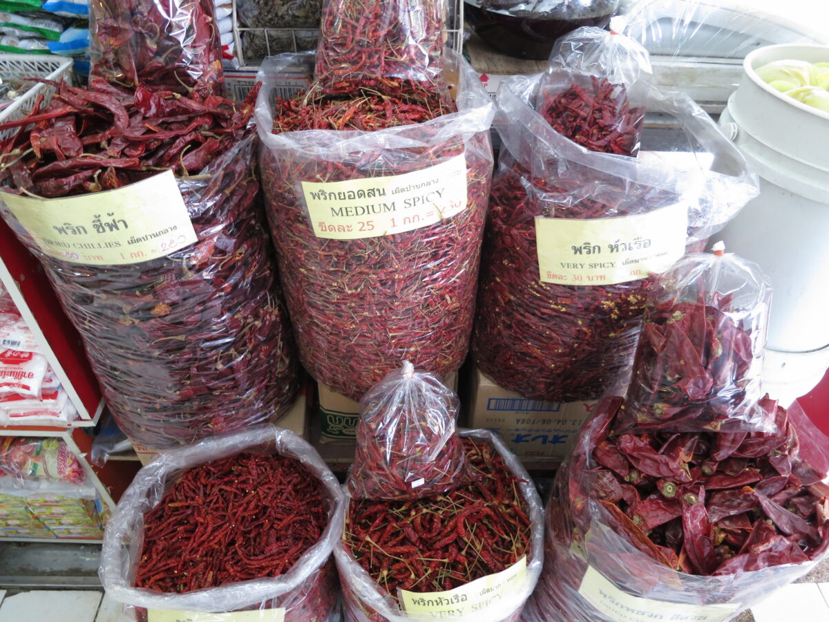 “Assorted dried red chillies in clear bags at Or Tor Kor Market, Bangkok.”