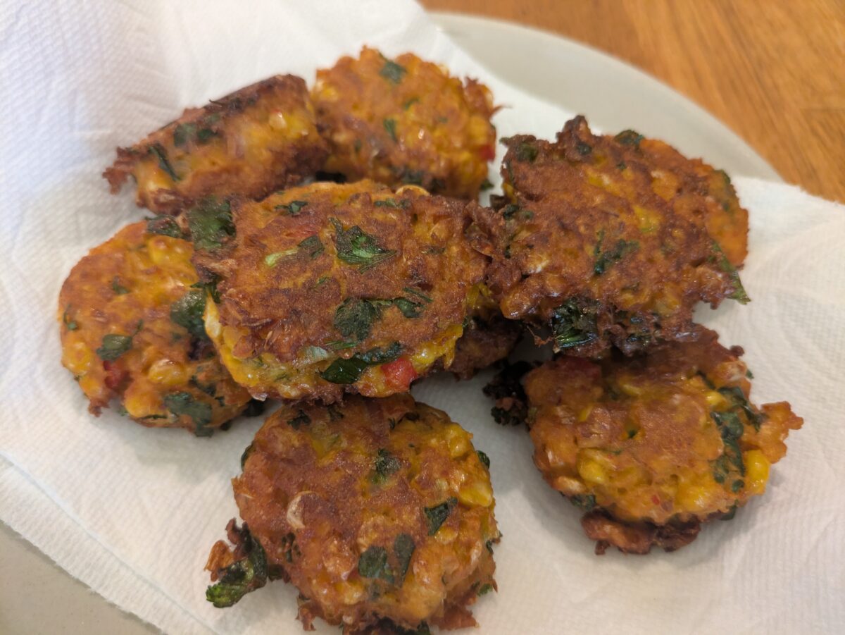 “Thai corn fritters draining on paper towels after frying.”