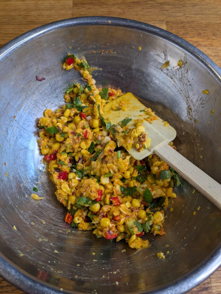 “Mixing curry paste, herbs, and flour into pureed corn for Thai corn fritters.”