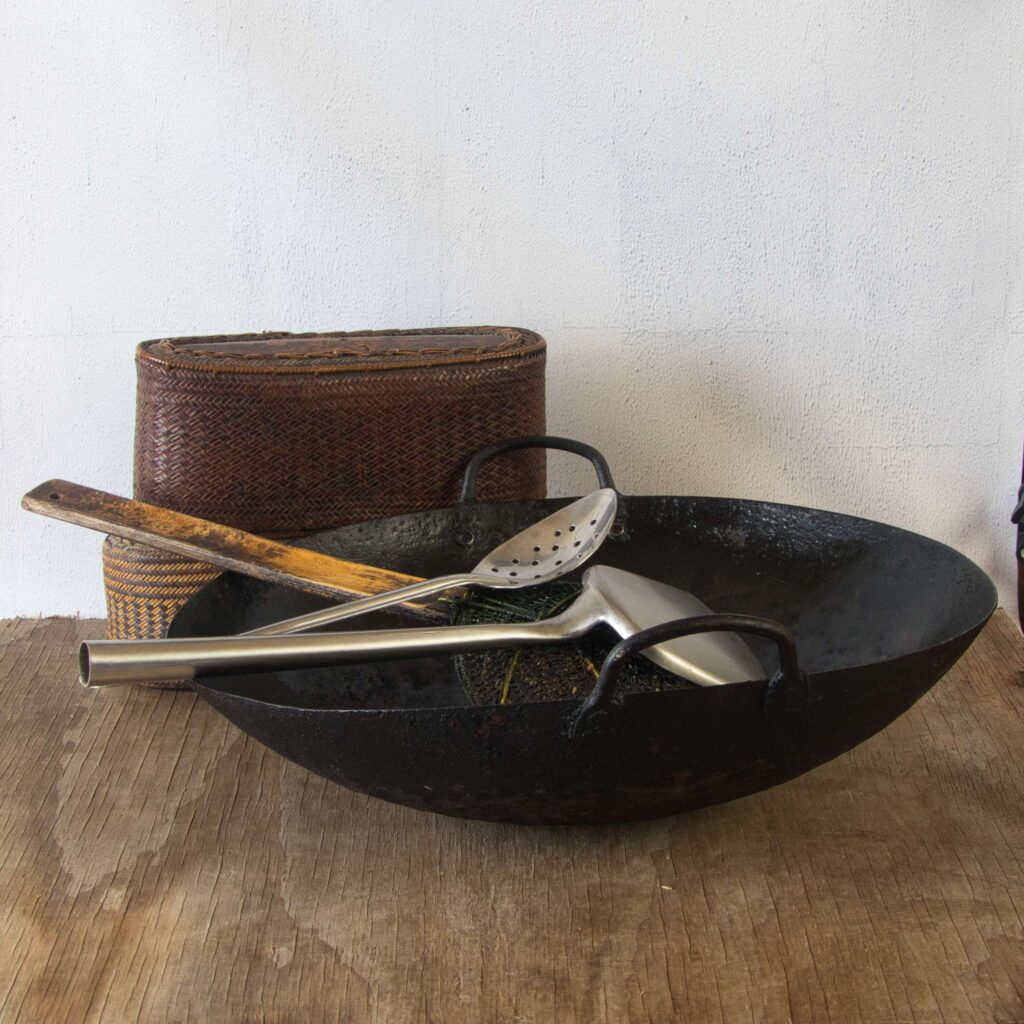 Wok over a gas flame used for cooking Thai chicken laab