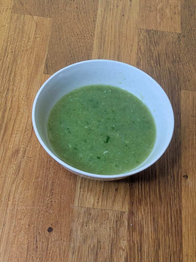 Thai hot chilli dressing in a bowl with green chilli, garlic and lime
