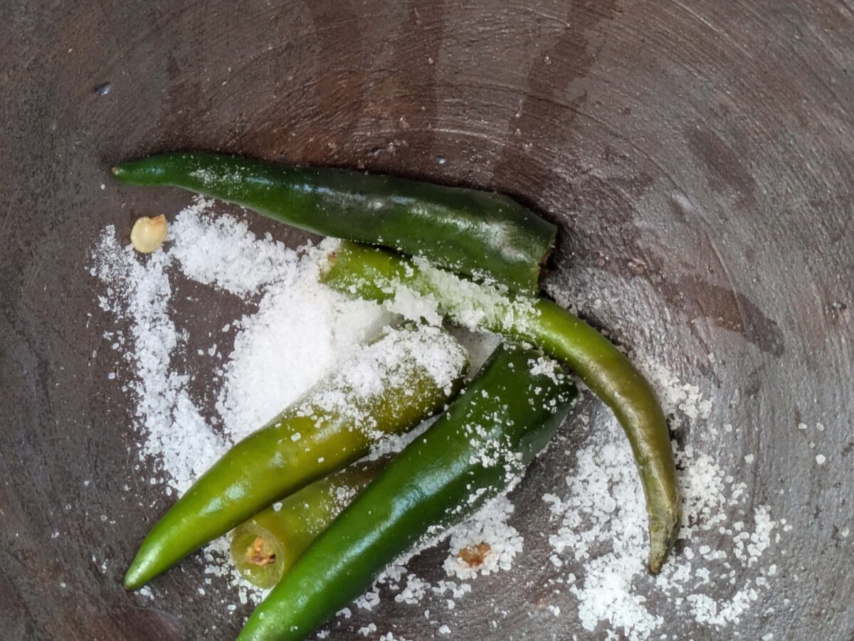 Green chilli and salt in a mortar to make Thai hot chilli lime dressing