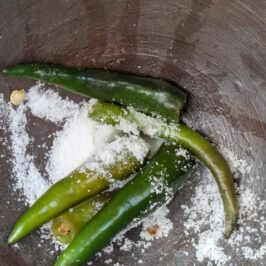 Green chilli and salt in a mortar to make Thai hot chilli lime dressing