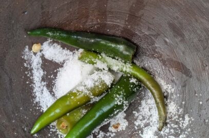 Green chilli and salt in a mortar to make Thai hot chilli lime dressing